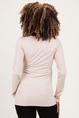 woman wearing a light pink ribbed long sleeve maternity top, showing the back view