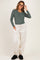 woman wearing a dark green long sleeve maternity top and light beige maternity joggers, smiling with glasses