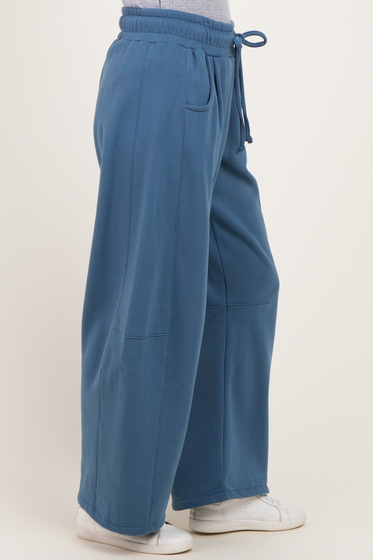 woman wearing blue wide-leg sweatpants with an elastic waistband and side pockets