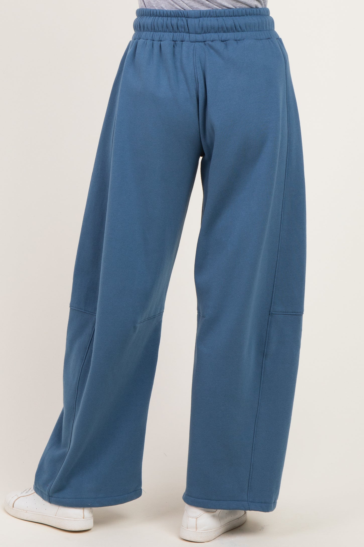 woman wearing blue wide-leg sweatpants with an elastic waistband and seam detailing