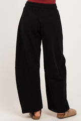 woman wearing black wide-leg sweatpants, shown from the back with a relaxed fit and elastic waistband