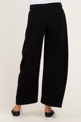 woman wearing black wide-leg maternity pants with a comfortable waistband from the back