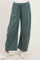 woman wearing teal wide-leg maternity sweatpants with pockets and drawstring waist
