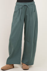 woman wearing oversized teal sweatpants with drawstring waist and side pockets