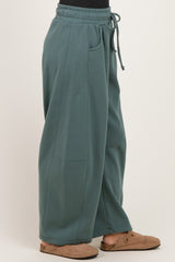 woman wearing oversized teal sweatpants with an elastic waistband and side pockets
