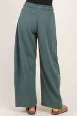 woman wearing teal wide-leg sweatpants with an elastic waistband and side pockets