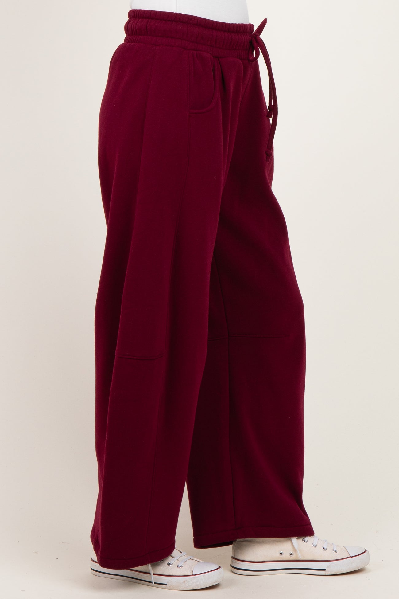 woman wearing burgundy wide-leg sweatpants with a drawstring waist and side pockets