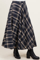 flared navy blue and tan plaid skirt with an A-line silhouette, styled with black ankle boots