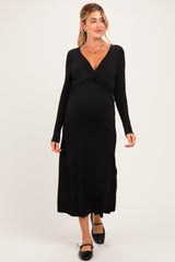 woman wearing a black long sleeve maternity dress with a twisted knot detail and a visible baby bump