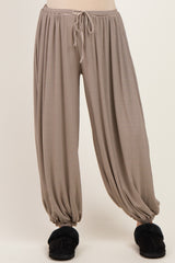 maternity wear striped harem pants with an elastic waist and cuffed ankles, model wearing fuzzy slippers