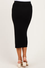 woman wearing a black ribbed maternity midi skirt, showing the back view and a sleek fit