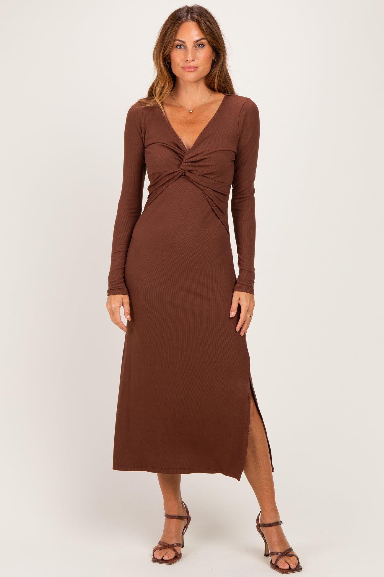 woman wearing a brown long sleeve maxi dress with a twist front and a side slit