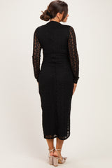 woman wearing a black lace maternity dress with long sleeves and a fitted silhouette, viewed from the back