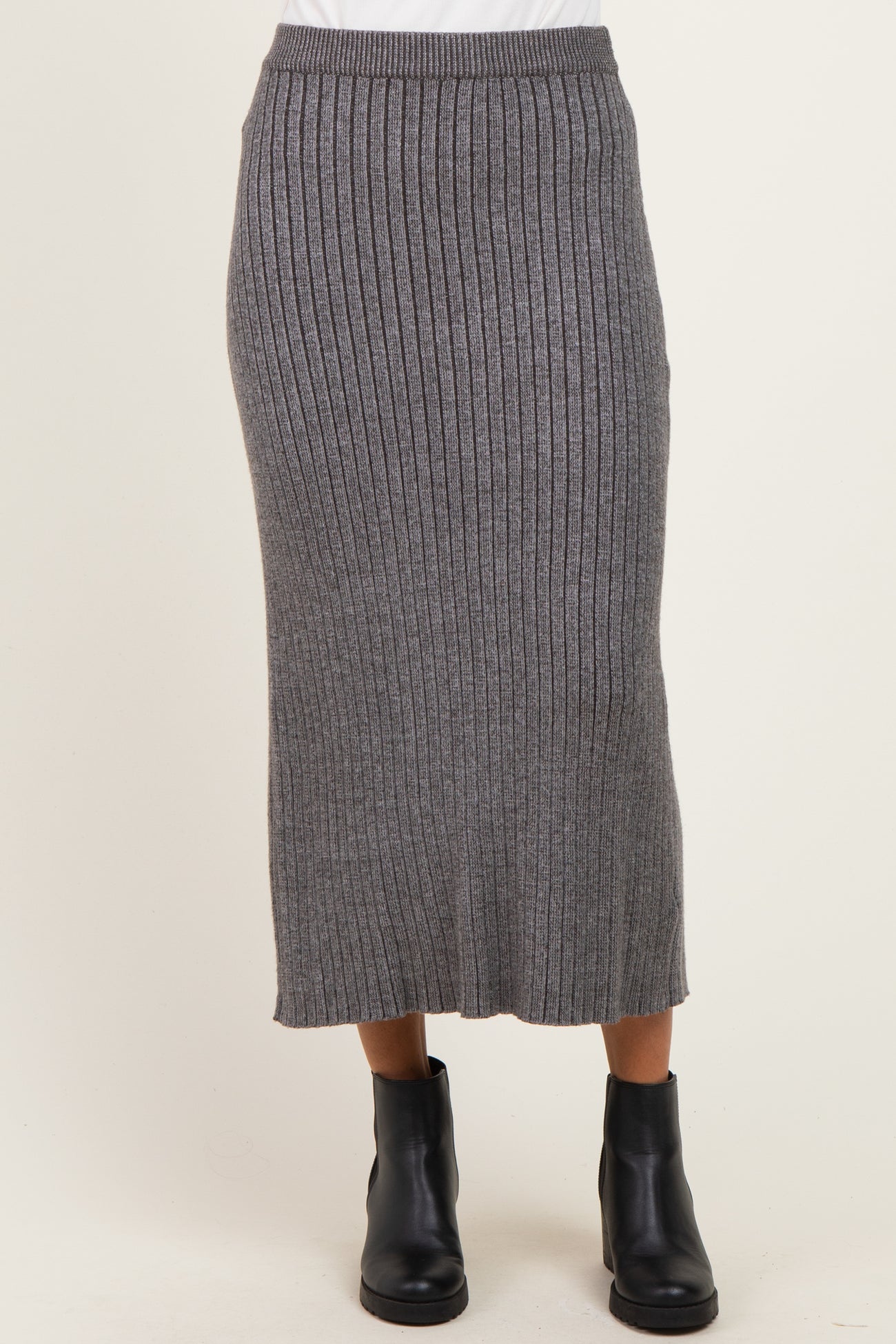 woman wearing a gray ribbed knitted midi skirt paired with black ankle boots