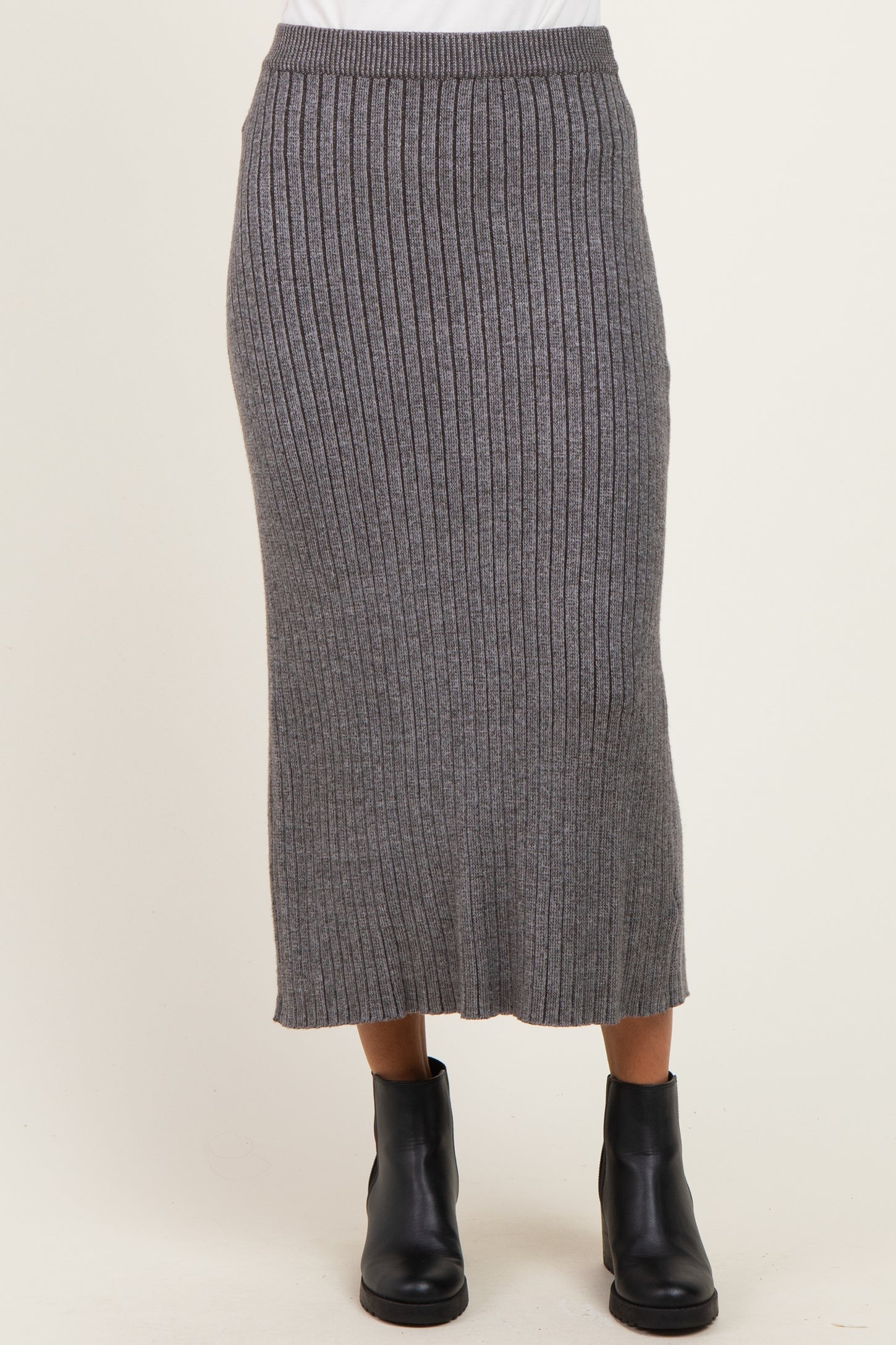 woman wearing a gray ribbed knitted midi skirt paired with black ankle boots
