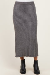 woman wearing a gray ribbed knitted midi skirt paired with black ankle boots