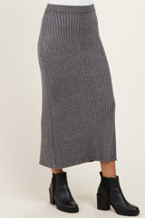 woman wearing a gray ribbed midi skirt with a fitted waistband and side slits, paired with black ankle boots