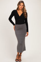 woman wearing a black long sleeve wrap top and a grey ribbed maternity maxi skirt