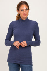woman wearing a navy ribbed long sleeve mock neck top with fitted silhouette and slight stretch