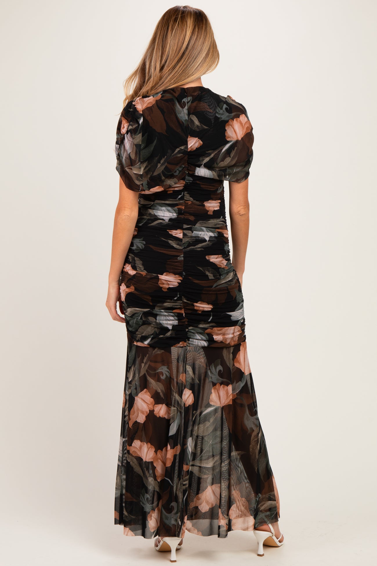 woman wearing a black floral maternity maxi dress with a ruched back and short puff sleeves