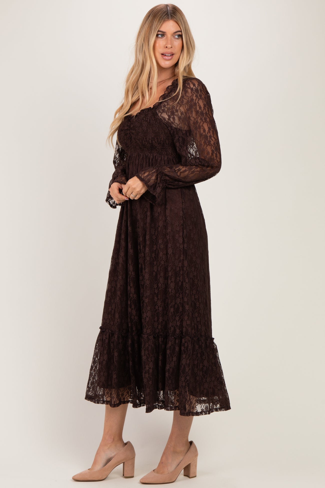 woman wearing a brown lace long sleeve maxi dress with a tiered hem and a fitted bodice