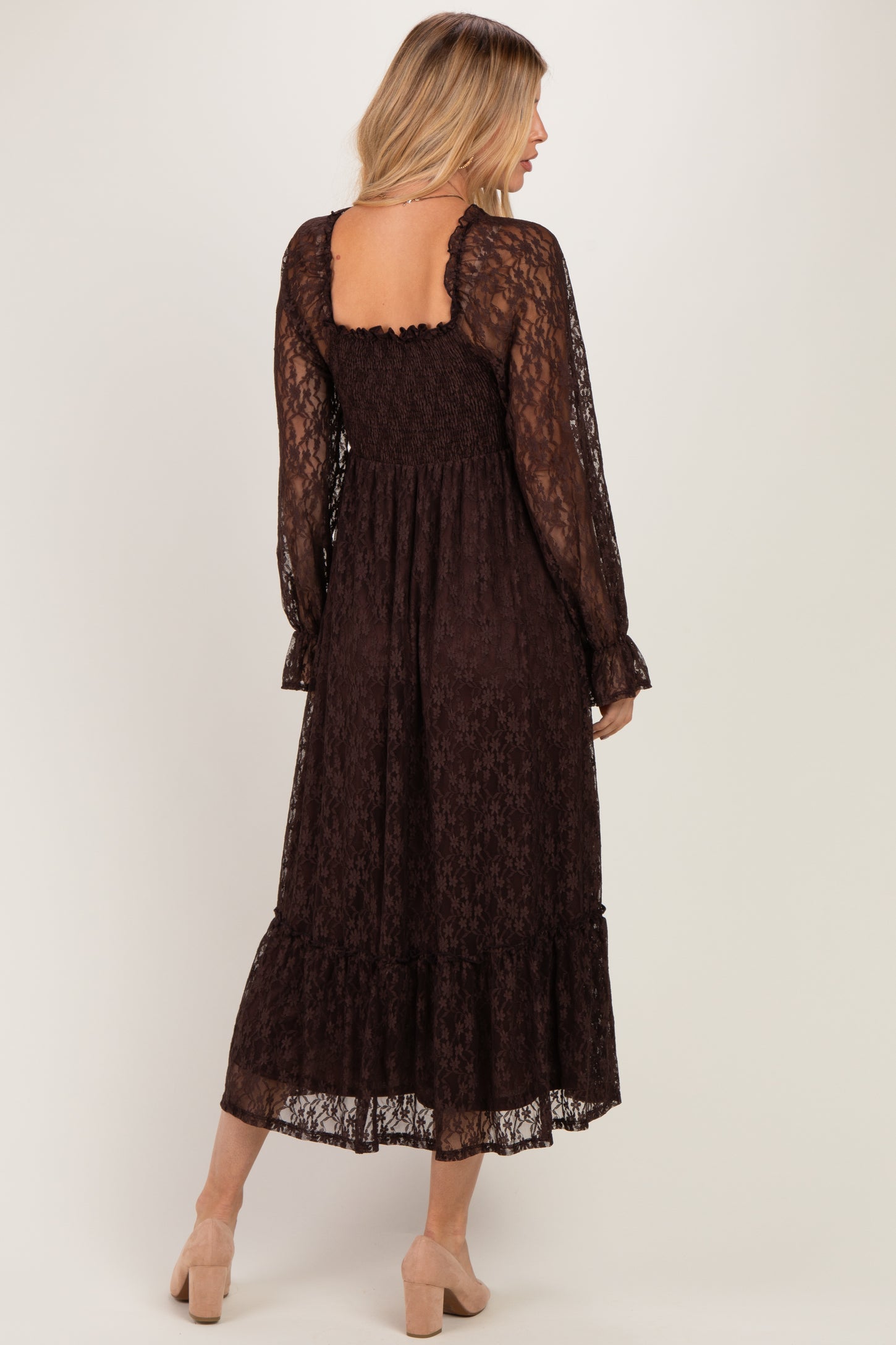 woman wearing a brown lace maxi dress with long sleeves and a ruffled hem, featuring a smocked back detail