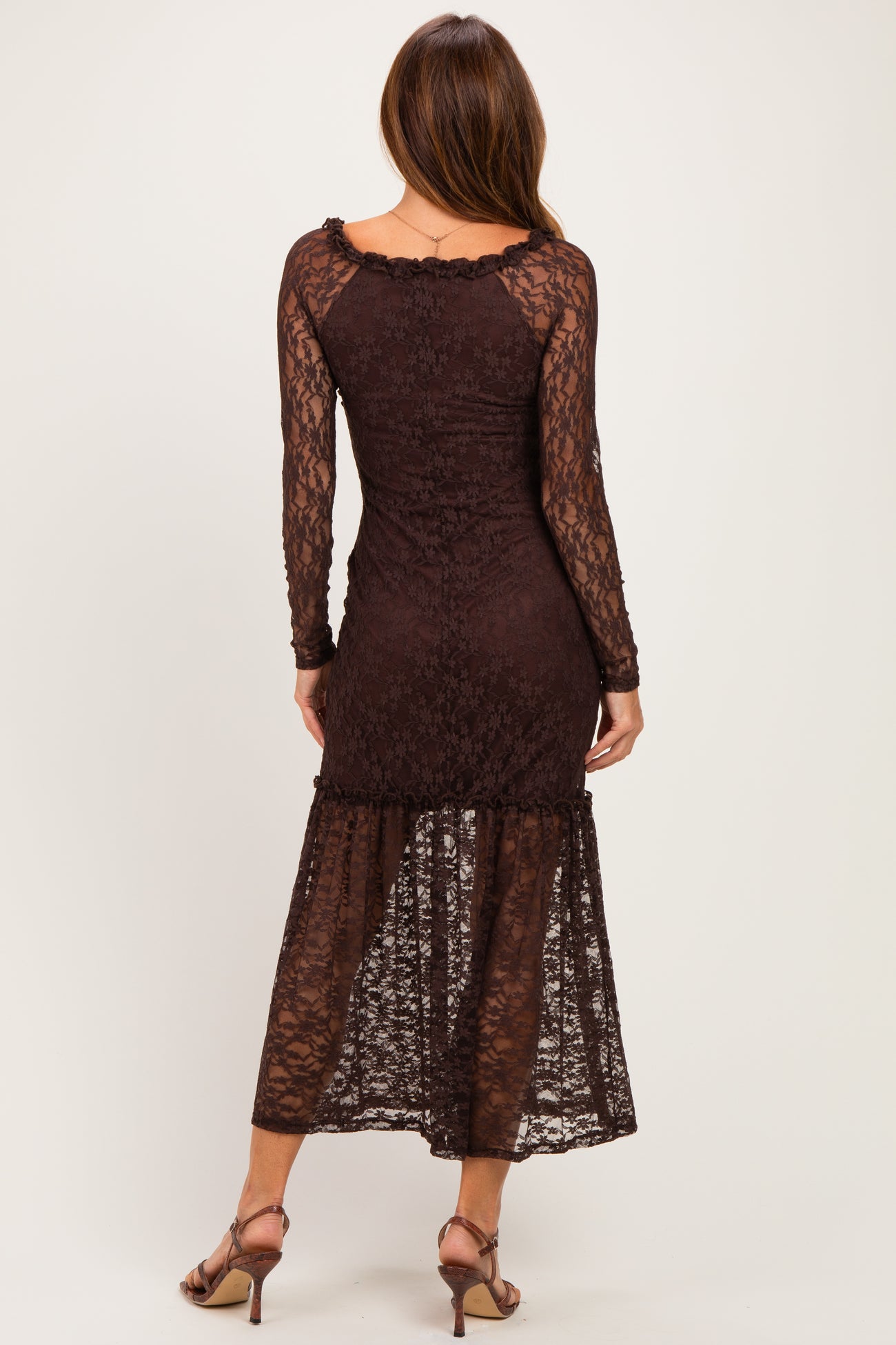 woman wearing a brown lace long sleeve midi dress with a tiered hem and a fitted silhouette