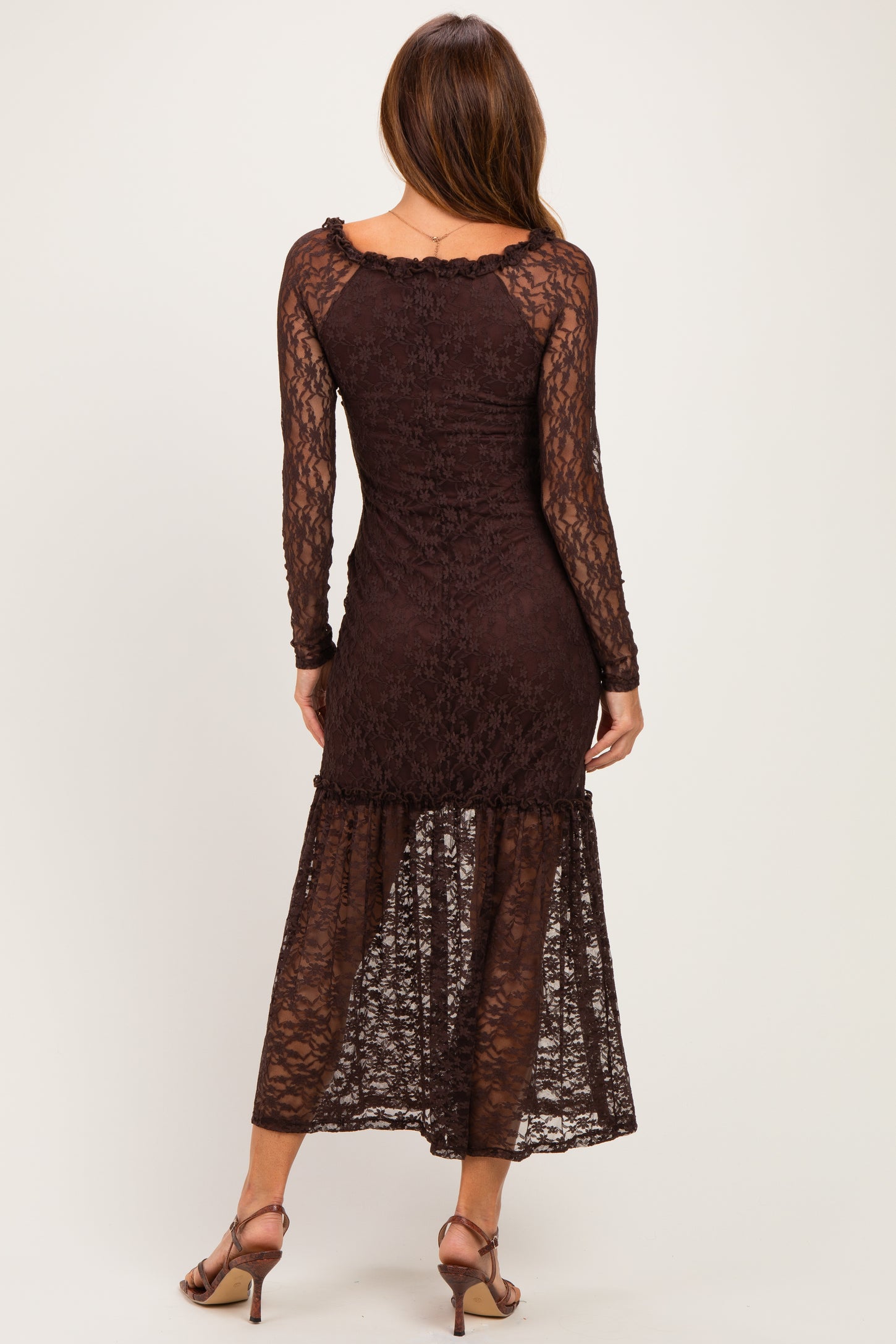 woman wearing a brown lace long sleeve midi dress with a tiered hem and a fitted silhouette