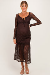 woman wearing a brown lace maternity dress with long sleeves and a tie front detail, showcasing her baby bump