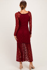 woman wearing a burgundy lace maxi dress with long sleeves and a tiered hem, viewed from the back