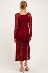 woman wearing a burgundy lace maternity dress with long sleeves and a fitted silhouette, showing a baby bump from the back