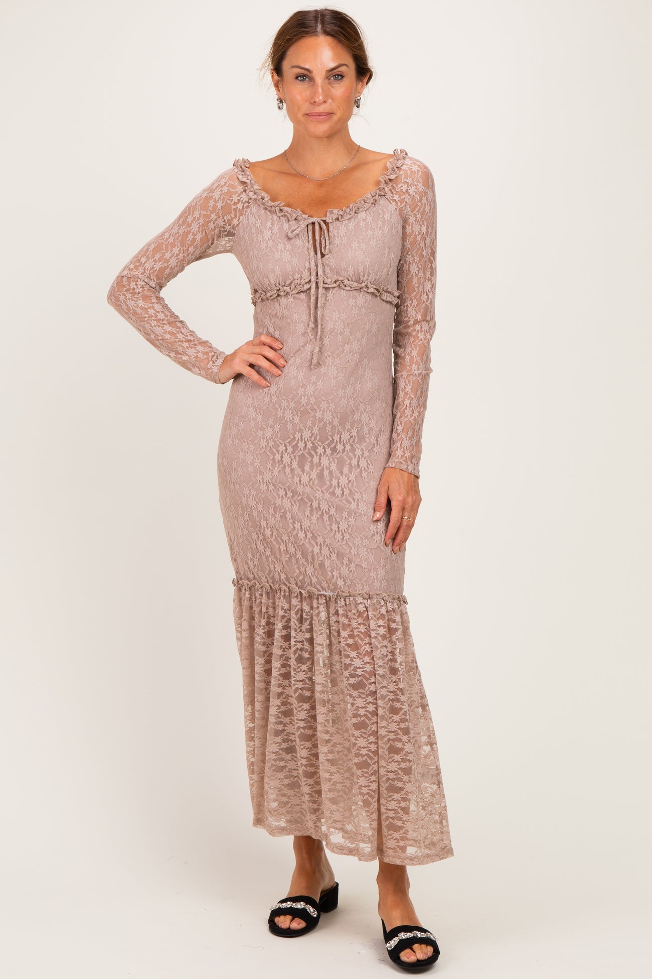 woman wearing a mauve long sleeve lace maxi dress with ruffle hem and drawstring detail at the waist