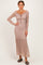 woman wearing a mauve long sleeve lace maxi dress with ruffle hem and drawstring detail at the waist