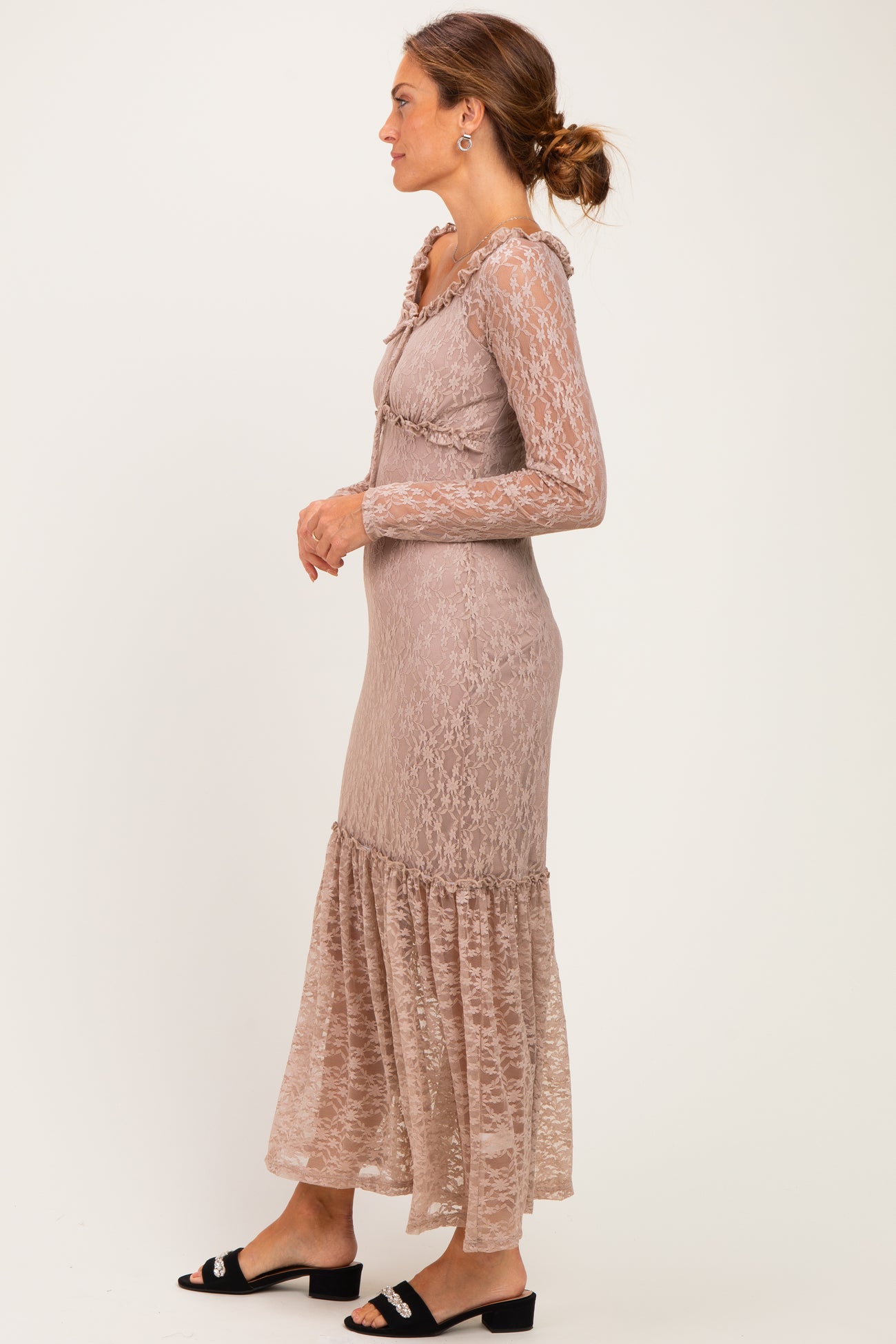 woman wearing a taupe long sleeve lace dress with ruffled details and a flared hem, styled with black sandals