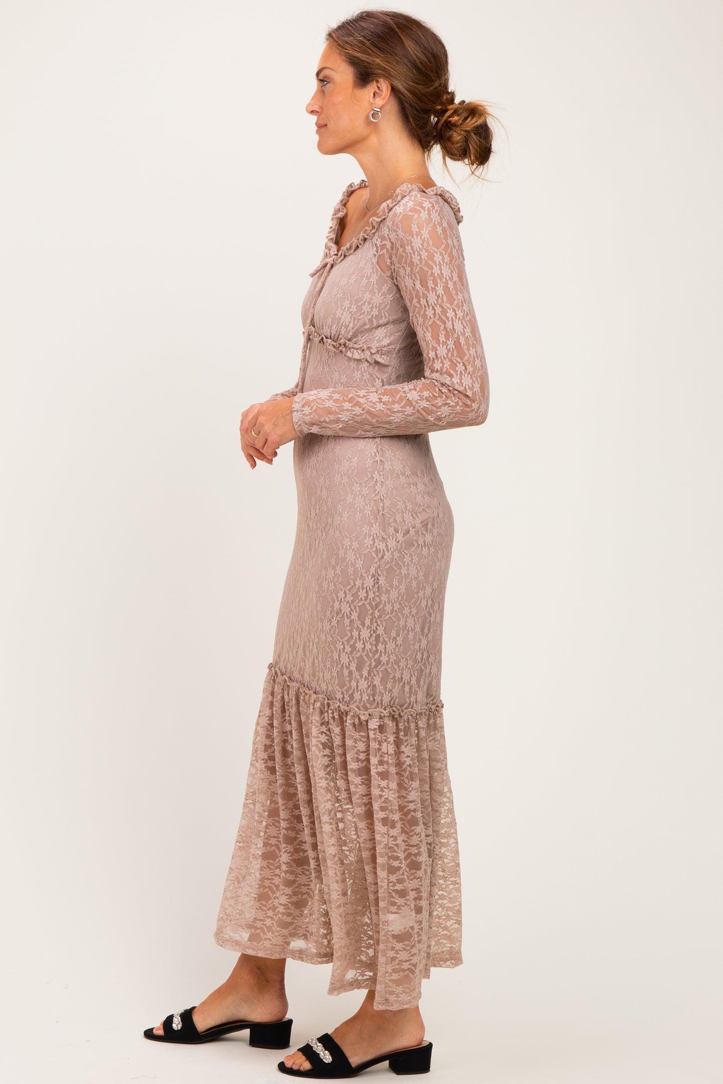 woman wearing a taupe long sleeve lace dress with ruffled details and a flared hem, styled with black sandals
