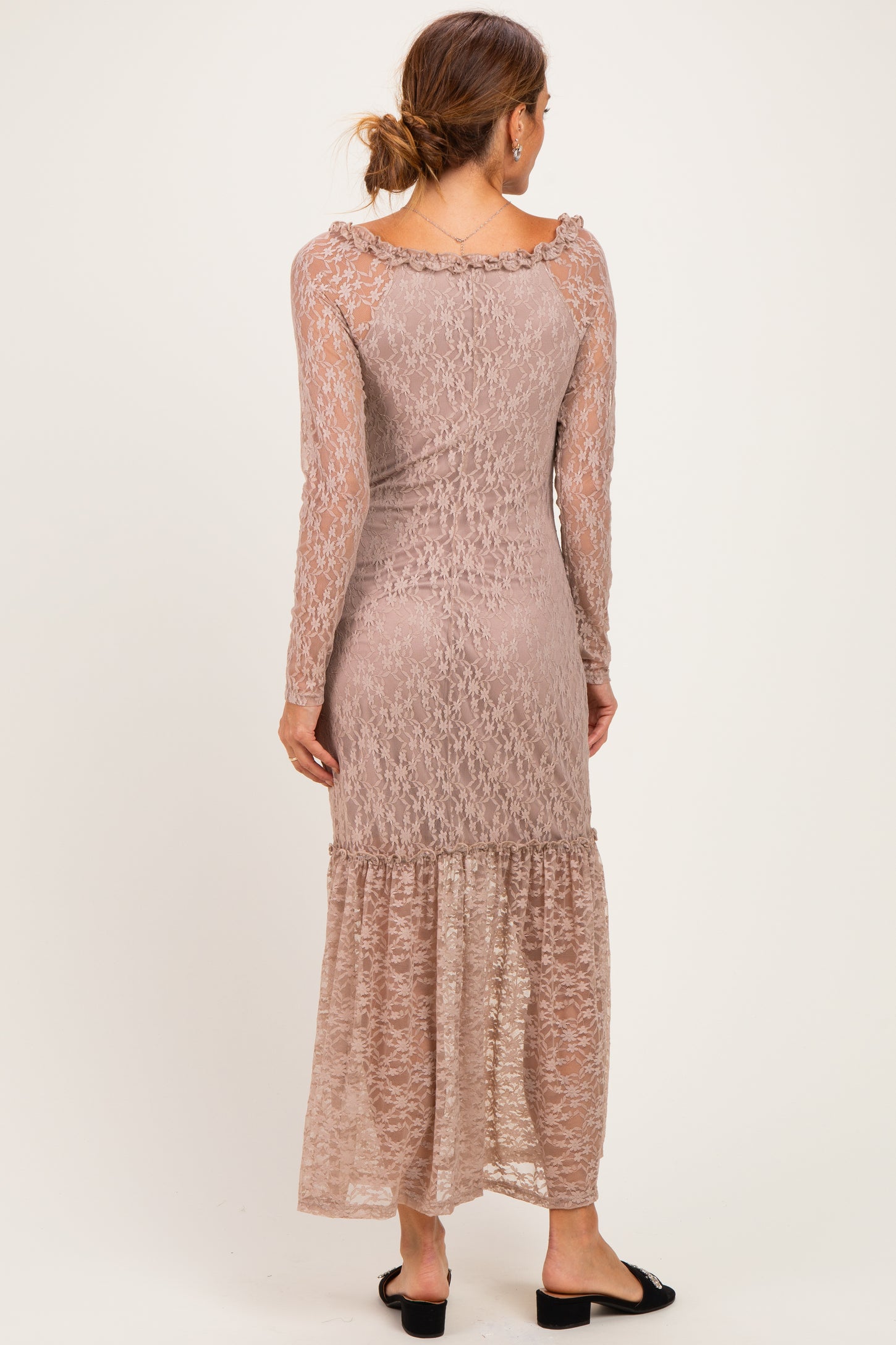 woman wearing a dusty rose long sleeve lace maxi dress with a ruffled hem and a fitted bodice