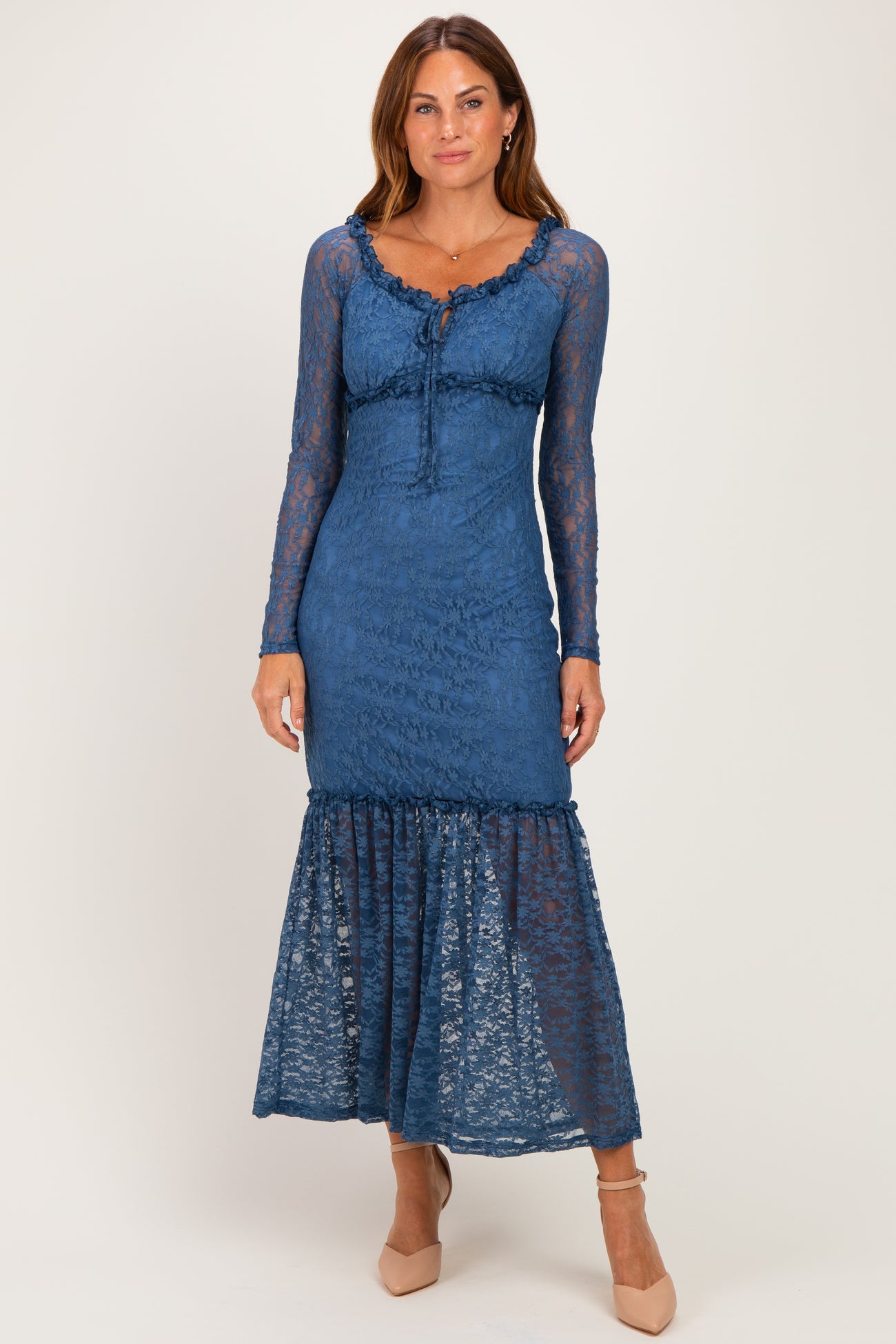 woman wearing a blue lace long sleeve maxi dress with a ruffled hem and a fitted bodice