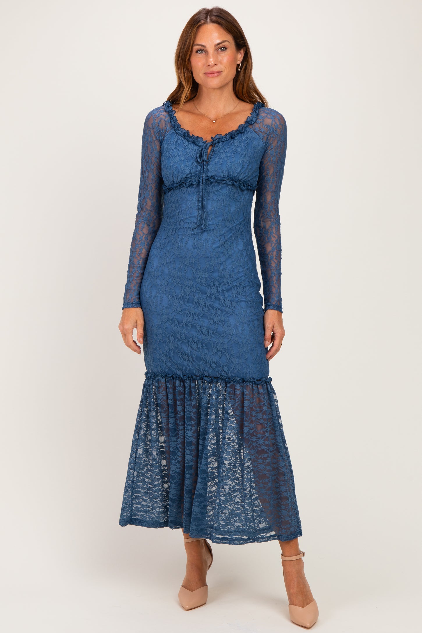 woman wearing a blue lace long sleeve maxi dress with a ruffled hem and a fitted bodice