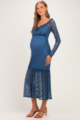 woman wearing a blue lace maternity dress with long sleeves and a ruffled hem, showcasing her baby bump