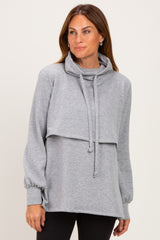 woman wearing a grey cowl neck sweatshirt with long sleeves and a relaxed fit