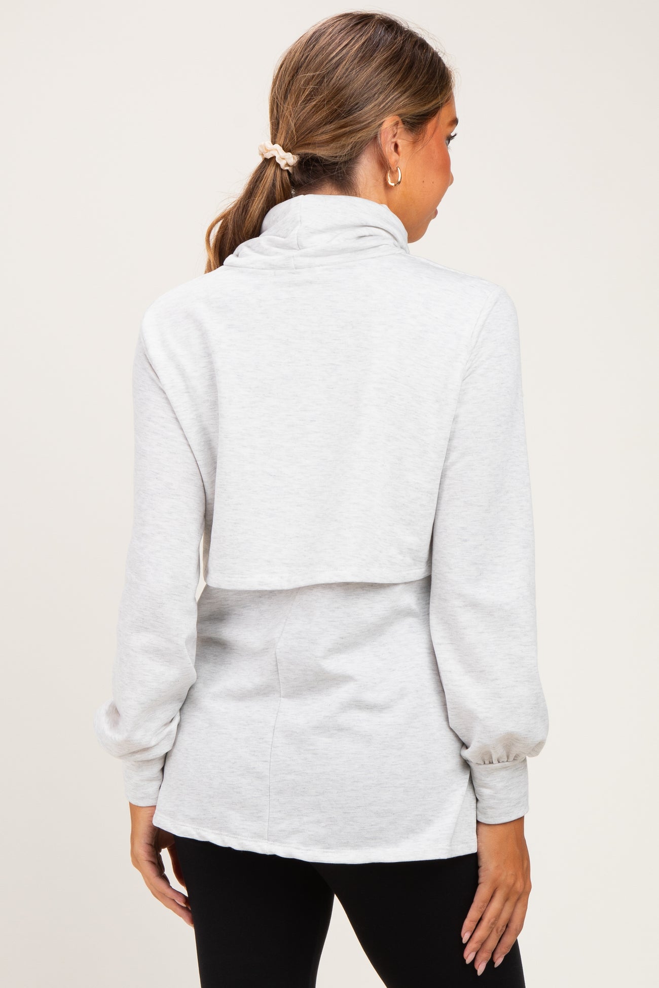 woman wearing a gray maternity sweatshirt with a cowl neck and balloon sleeves, showing the back view