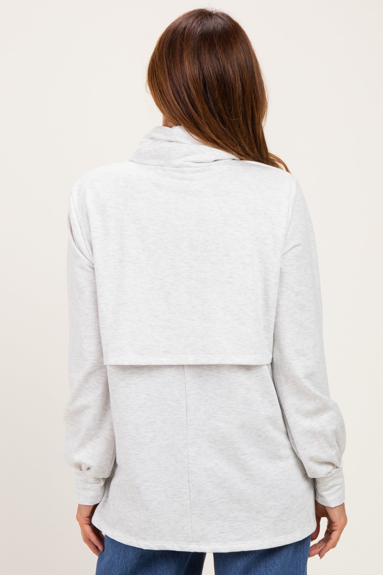woman wearing a gray backless long sleeve sweatshirt with puffed sleeves, showing a relaxed fit from the back