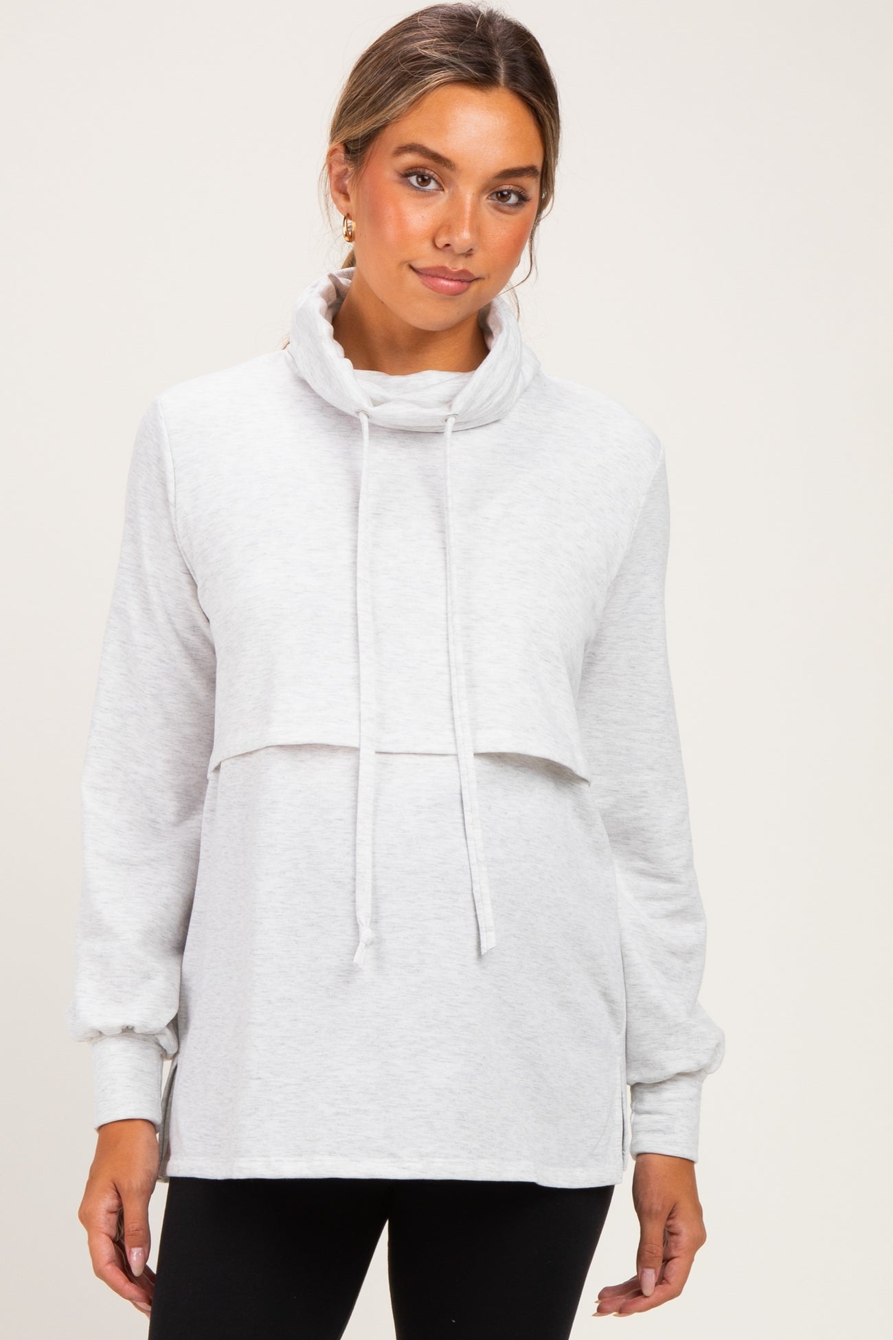 woman wearing a light grey maternity sweatshirt with a cowl neck and layered front detail