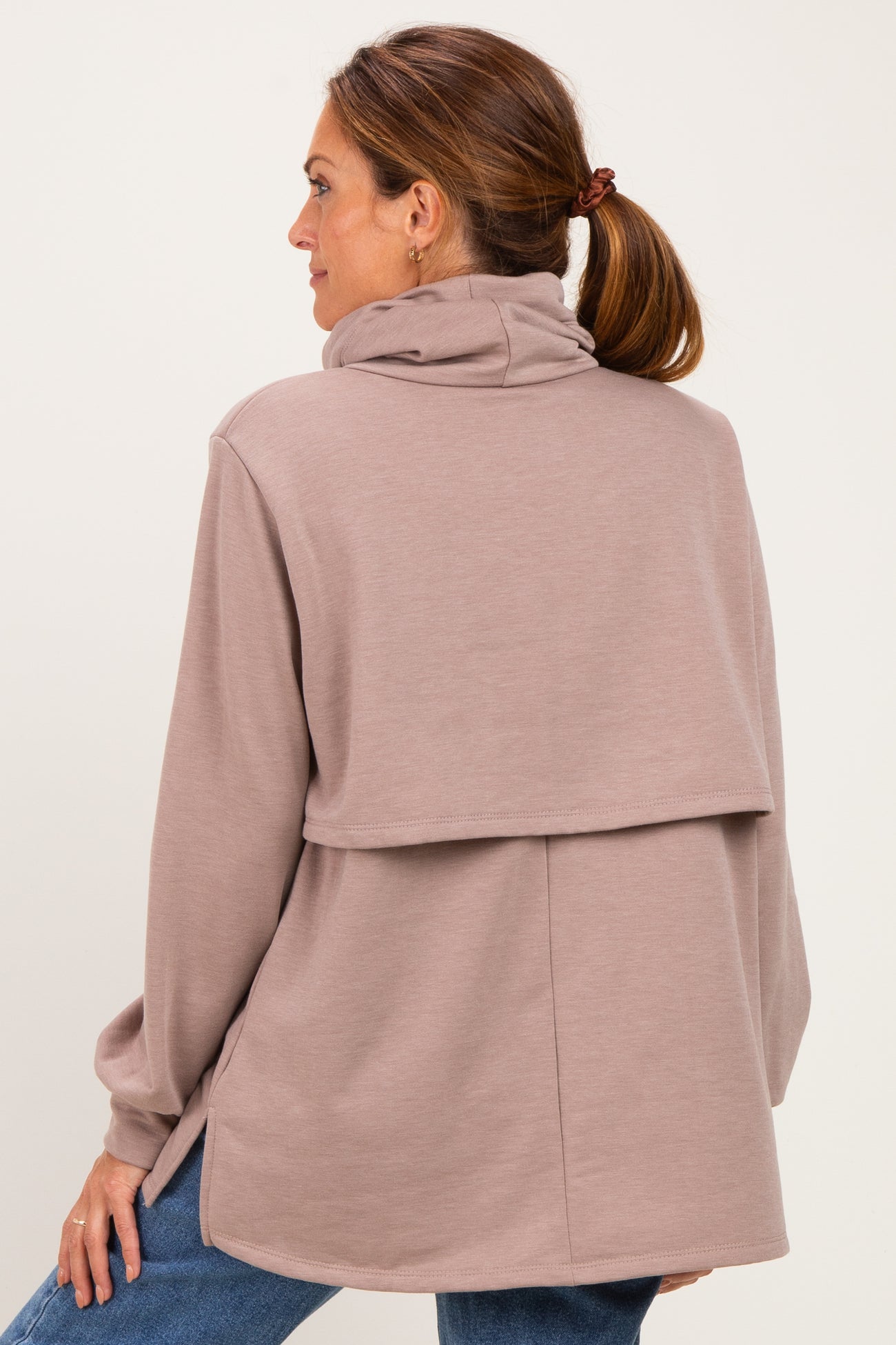 woman wearing a taupe cozy cowl neck sweatshirt with a stylish layered back detail