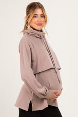 woman wearing a mauve maternity hoodie with a cowl neck and side slits, holding her baby bump