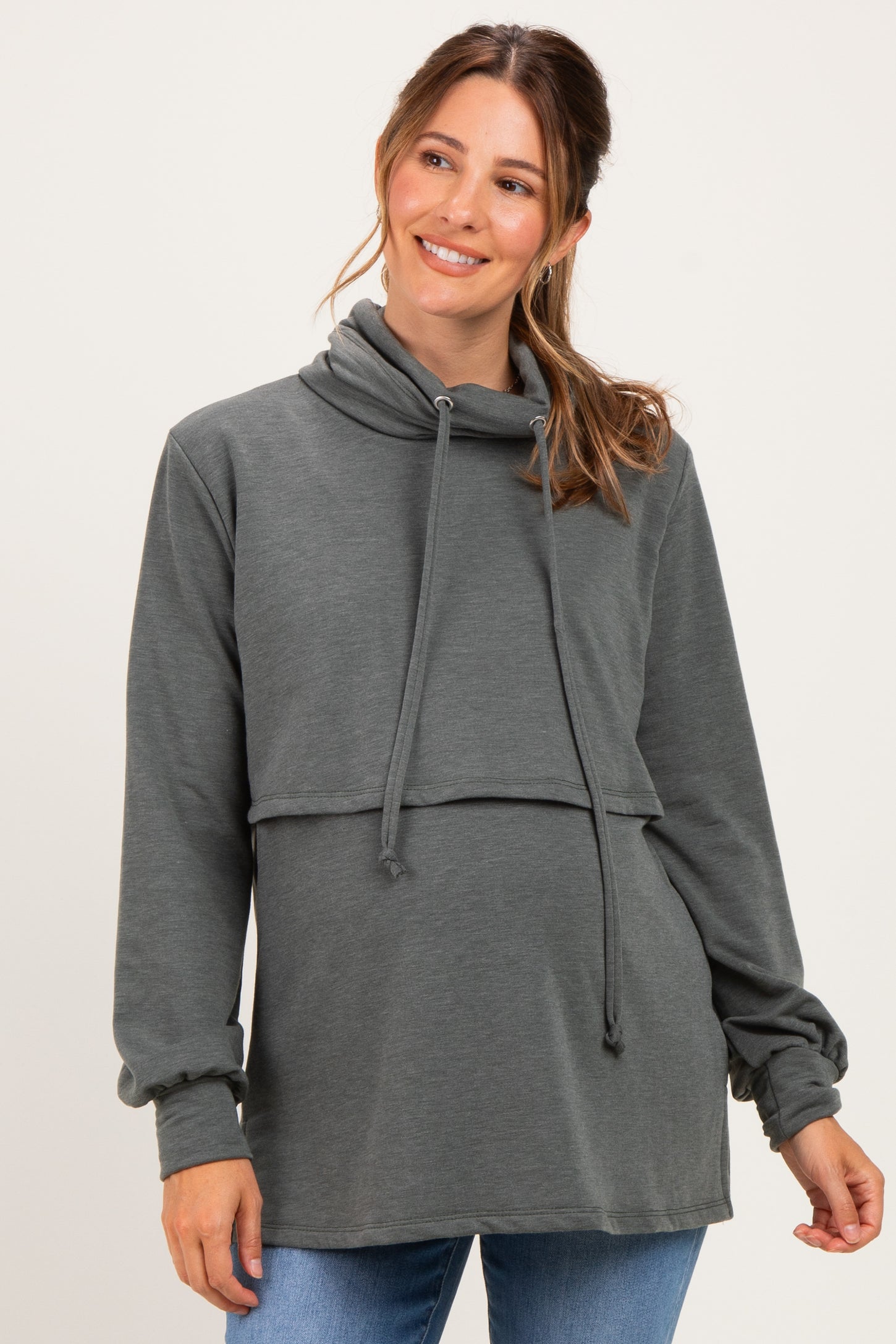 woman wearing a dark gray maternity sweatshirt with a cowl neck and cropped style, showing her baby bump