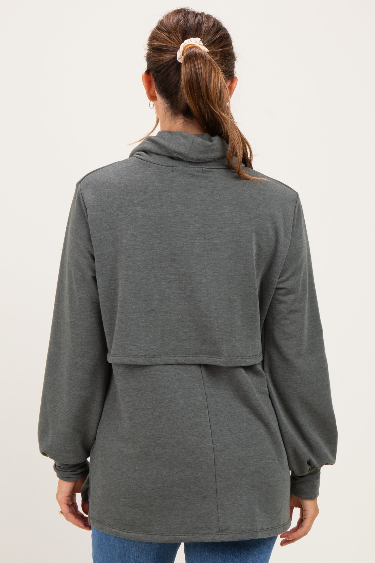 woman wearing a dark gray maternity top with a high neck and balloon sleeves, displaying a relaxed fit from the back