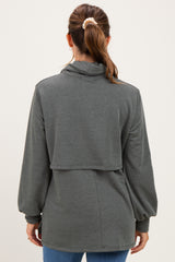 woman wearing a dark gray maternity top with a high neck and balloon sleeves, displaying a relaxed fit from the back