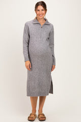 woman wearing a grey maternity sweater dress with a zip collar and side slit, showcasing her baby bump