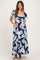 woman wearing a navy blue floral maternity maxi dress and holding her baby bump